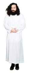 Man wearing Jesus Christ costume with hand on stomach because indigestion, painful illness feeling unwell. Ache concept.