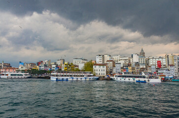 seagulls and clouds over Karakoy harbor and Galata tower (Istanbul, Turkiye) 