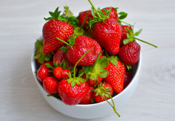fresh ripe strawberry in white bowl on wooden tabel
