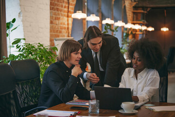 Collaborative process of multicultural, female and male, skilled students during brainstorming meeting in library. Concept of business, work and study, job and learning, cooperation, education.