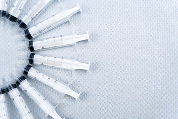 Syringes arranged in a semicircle on the left edge of the image to create copy space