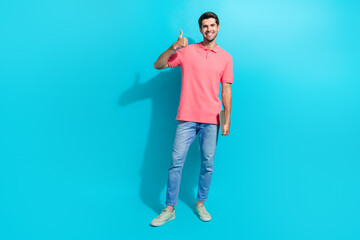 Full body length photo of young positive successful guy thumb up symbol bring light weight netbook isolated on aquamarine color background
