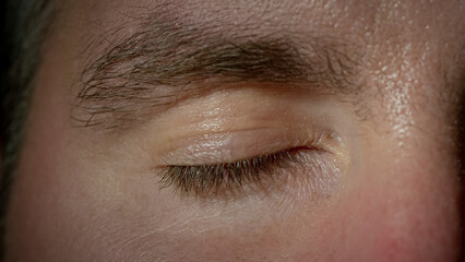 Closed human eye of a male close-up shot. Waking time and life-changing moment concepts.