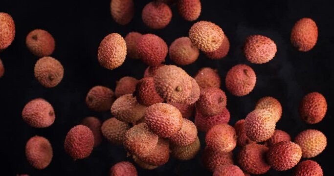 Super slow motion of fresh bio organic pieces are flying lychee fruits and at 1000 fps isolated on black background.