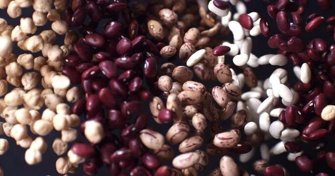 Super slow motion macro of pile dry quality legumes mix explosion with flying grains on isolated on black background at 1000 fps.