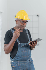Professional of man architect industrial engineer Standing in the office, foreman in helmet using laptop working with new construction project architectural plan.