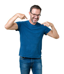 Fototapeta premium Handsome middle age hoary senior man wearin glasses over isolated background looking confident with smile on face, pointing oneself with fingers proud and happy.