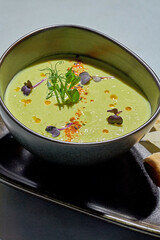 Pea cream soup in a bowl. Light background. Close-up