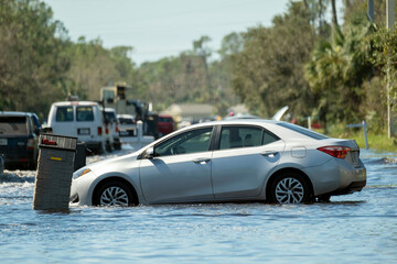 Hurricane flooded street with broken car in surrounded with water Florida residential area....