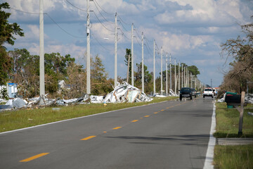 Fototapeta premium Metallic scrap rubbish on roadside from hurricane severely damaged houses in Florida residential area. Aftermath of natural disaster