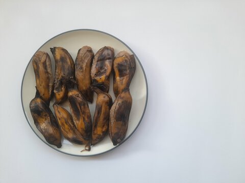boiled kepok banana (pisang kepok) food on a plate on a white background. background concept of healthy food, traditional food, food recipes, breakfast, lifestyle, nutrition, health, nutritious