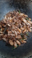 Stir fried salted squid (cumi asin) in a frying pan seen above. concept background of seafood, healthy food, food recipes, dish, cuisine, gourmet, restaurant, culinary, lifestyle, ingredient, cooking