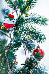 a branch of a Christmas tree with decorations on a light background