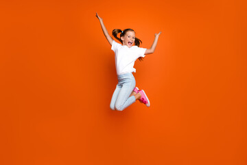 Full body photo of active cheerful schoolchild rejoice have good mood isolated on orange color background