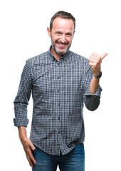 Middle age hoary senior man over isolated background smiling with happy face looking and pointing to the side with thumb up.