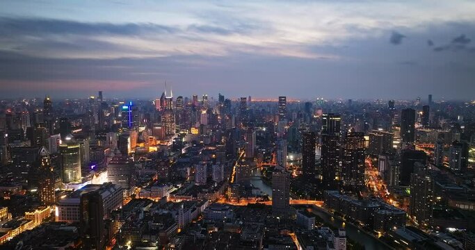 Aerial back shot of Shanghai financial district skyline and streets at night