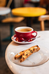 Cup of black coffee and cantucci or biscotti cookies in a cafe coffee-shop with copy space