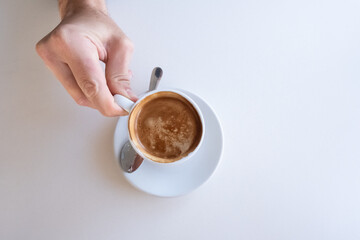 coffee on a coffee shop table with a person's hand