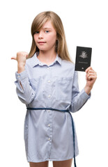 Young blonde toddler holding australian passport pointing with hand and finger up with happy face smiling