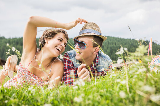 gl&uuml;ckliches Paar liegt in einer Wiese a in den Bergen, &Ouml;sterreich