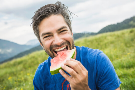 man close portrait having picnic with watermelon in the mountain 