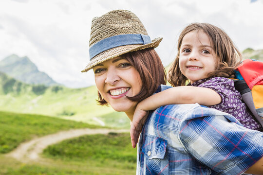 Frau mit Kind Huckepack beim wandern mit Freude in den Bergen, &Ouml;sterreich