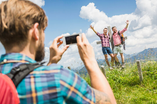 Mann macht Foto von Freunden beim wandern in den Bergen, &Ouml;sterreich