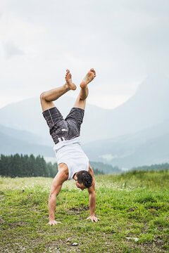 man dancing having fun rainshower in the mountains