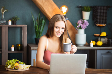 Young woman with mug using laptop