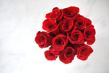 Nosegay bouquet arrangement of red roses from above, simple white background