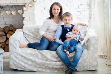 Happy mother with her children having fun in living room