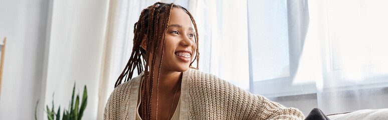 joyous attractive african american woman in homewear with braces posing and looking away, banner