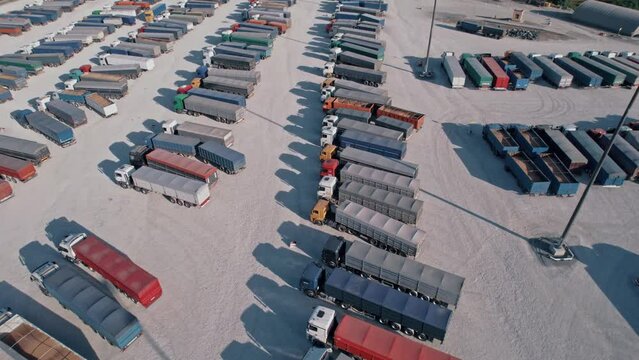 Large parking lot of wheeled trucks exporting crop