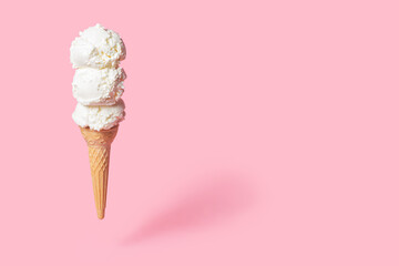 summer funny creative concept of flying wafer cone with scoops of ice cream on pink background, copy space