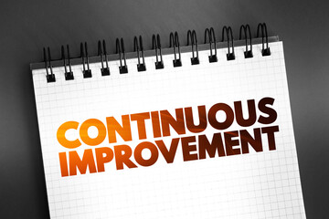 Continuous Improvement text on notepad, business concept background
