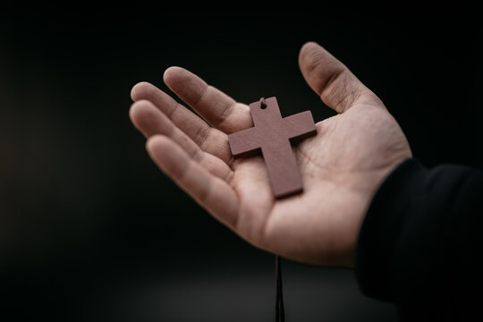 Portrait of young beautiful boy praying to God with rosary. Horizontal image.