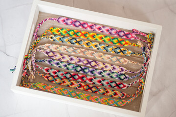 Fototapeta na wymiar Bracelets brésiliens colorés - bracelets d'amitié artisanaux dans un plateau en bois