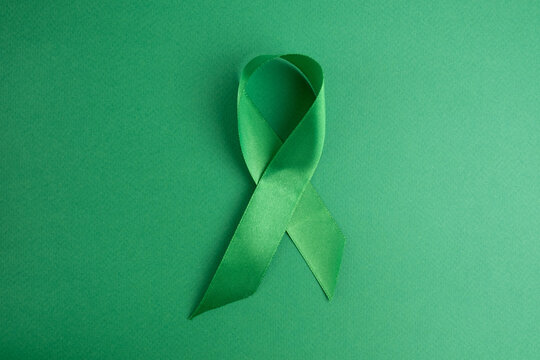 World Lymphoma Awareness Day. Green ribbon on a green background. Kidney Cancer Awareness Month. World Mental health awareness day. World bipolar day.Banner. Copy space