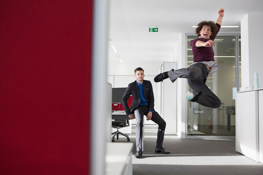 zwei M&auml;nner im Businessoutfit springen vor Freude im B&uuml;ro, M&uuml;nchen, Deutschland