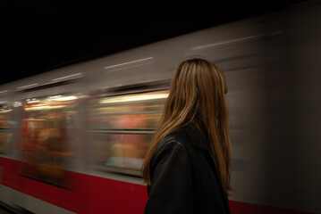 Girl staring at a leaving subway with melancholic vibes.