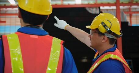 Workers partners in uniform Talking on a Meeting in Metal Construction Manufacture industry factory, Engineers man colleagues industrial discussing project work in warehouse. Team work