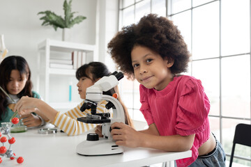 Mix race kid girl funny learning study science of of use microscope and test chemical with tube	