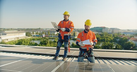 engineer man contractor worker architect construction manager in uniform and hardhat work to maintenance checking an operation and efficiency performance of photovoltaic solar panels on roof - obrazy, fototapety, plakaty