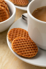 Fresh baked mini stroopwafels, syrup waffles, close up and a cup of coffee