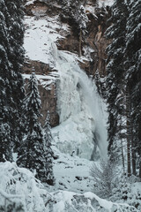 Fototapeta na wymiar arctic landscape of frozen water from a waterfall in the mountains at a cold winter day