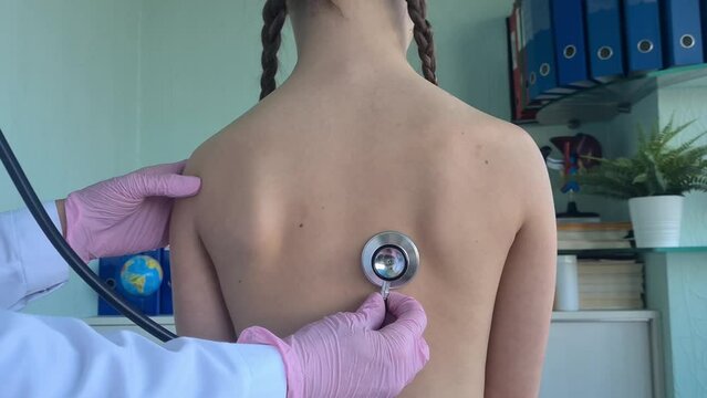 Little girl has lungs examined by doctor with stethoscope. Cough bronchitis or diagnosis of pneumonia