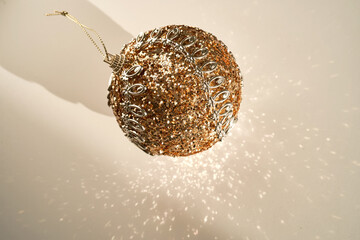 Shiny Christmas ball of gold color on a white background.