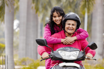 Indian Senior woman with Grand daughter Driving Scooter moped Enjoying Life ,Insurance Concept © Photographielove