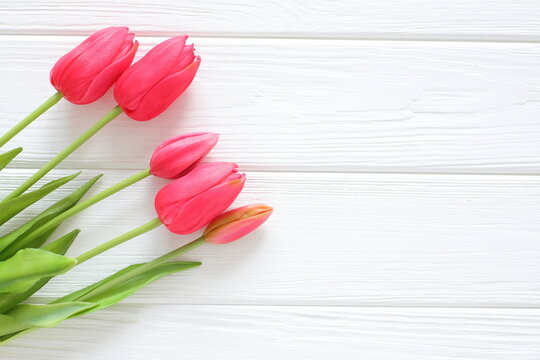 Red tulips on white wooden background, women´s day, mothers day, valentine, wedding, birthday, freeting card