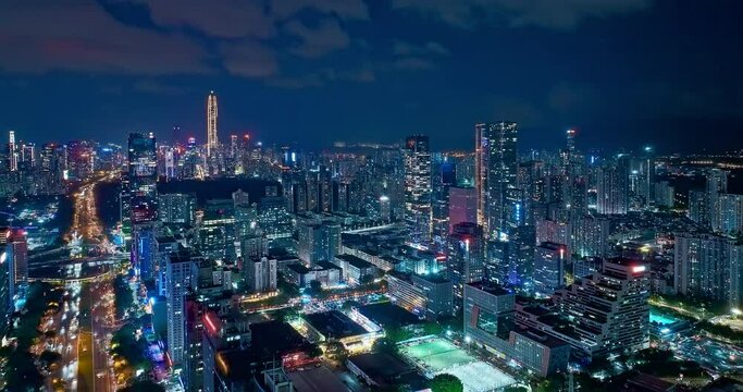 Aerial forward shot of Shenzhen financial district skyline and streets at night